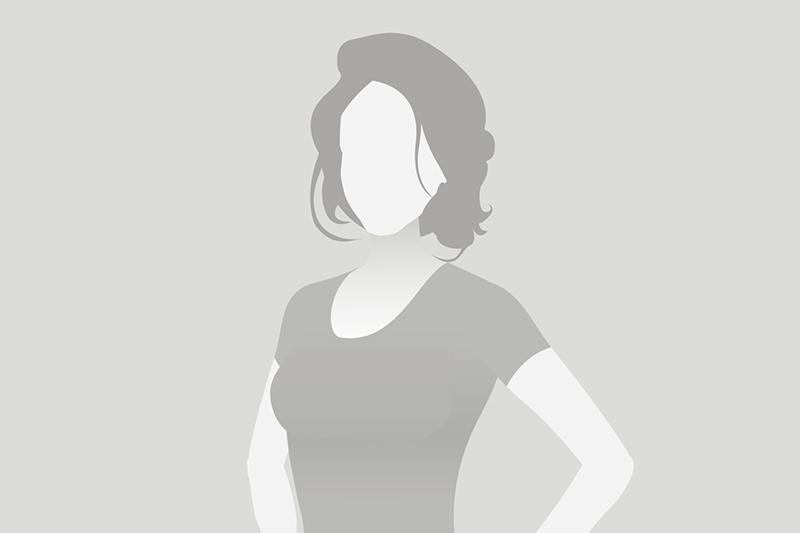 Silhouette einer Frau mit kurzem Haar, die in einem schlichten T-Shirt steht, vor neutralem Hintergrund.